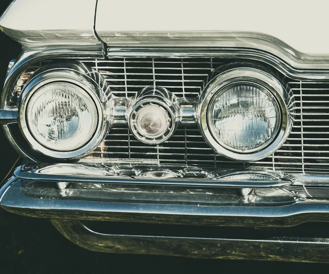 Close-up of vintage car headlights and grille